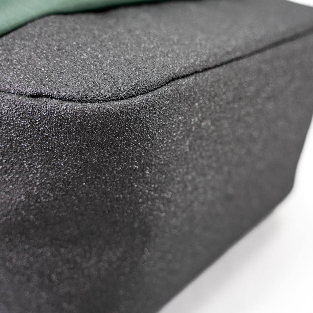 Close-up of the green FORWRD Court Ranger pickleball backpack’s reinforced black base, highlighting the textured, abrasion‑resistant material for durable on‑court performance.