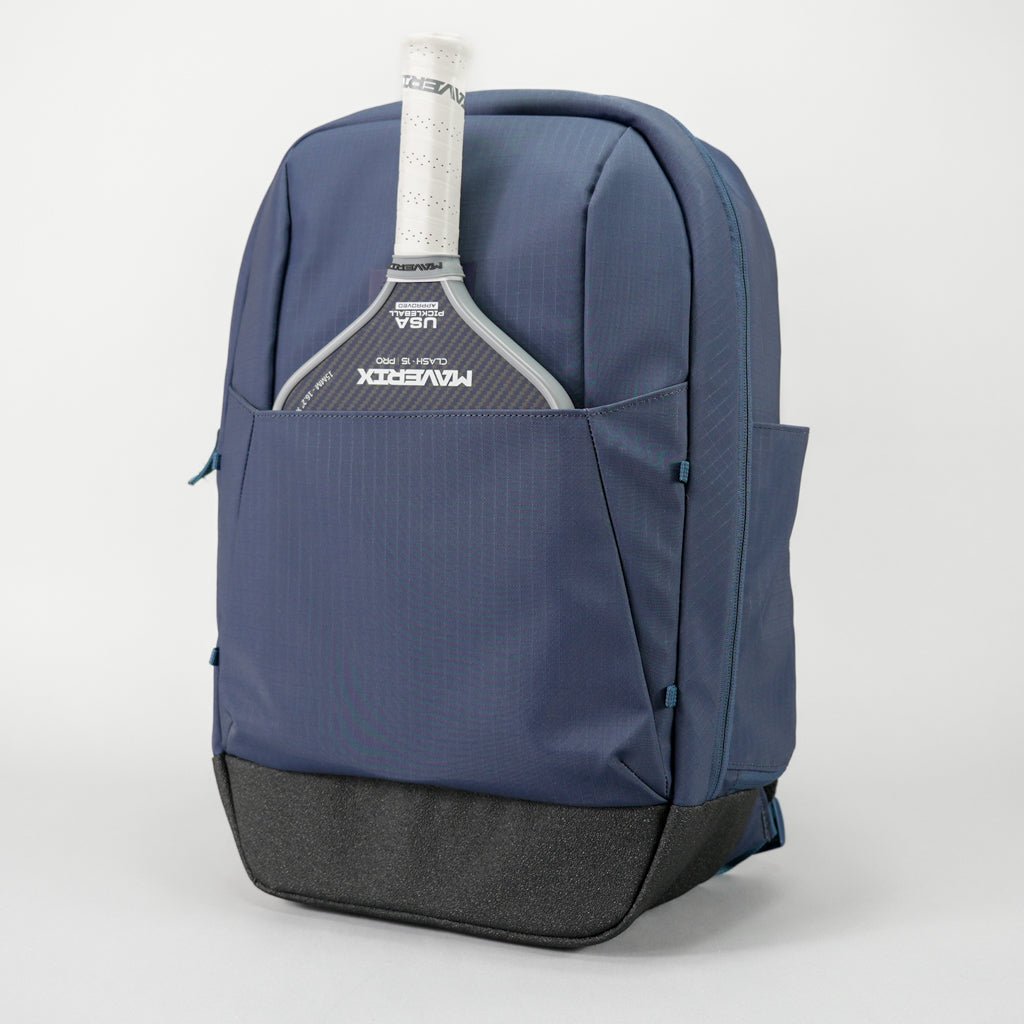 Blue backpack with a tennis racket in the front pocket on a light gray background