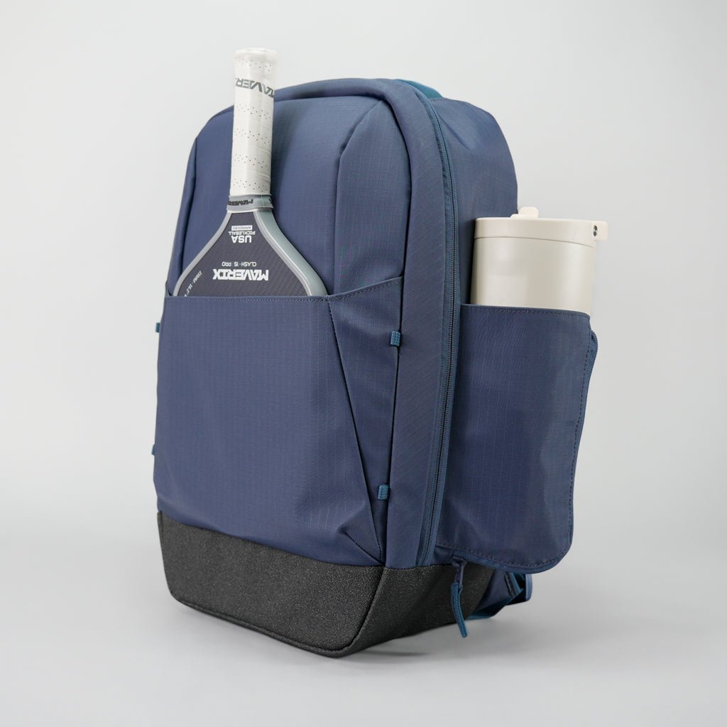 Blue backpack with a tennis racket and cup holder on a light gray background