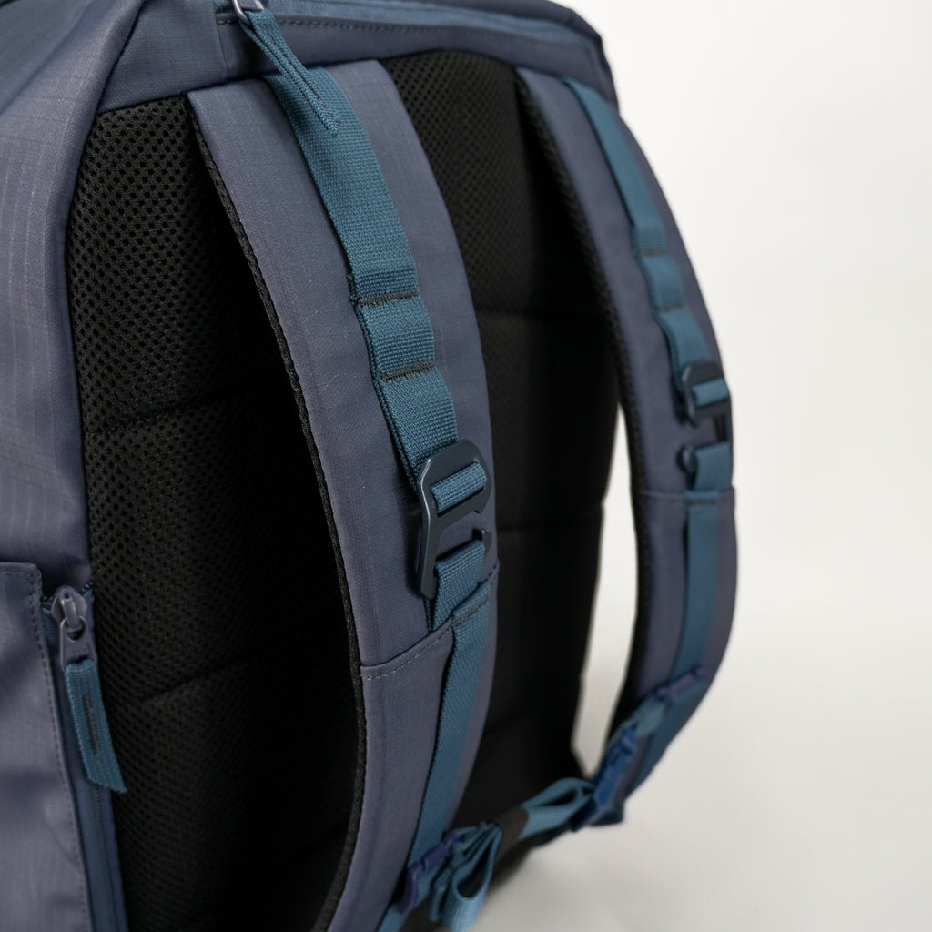 Close-up of a blue backpack with straps on a white background