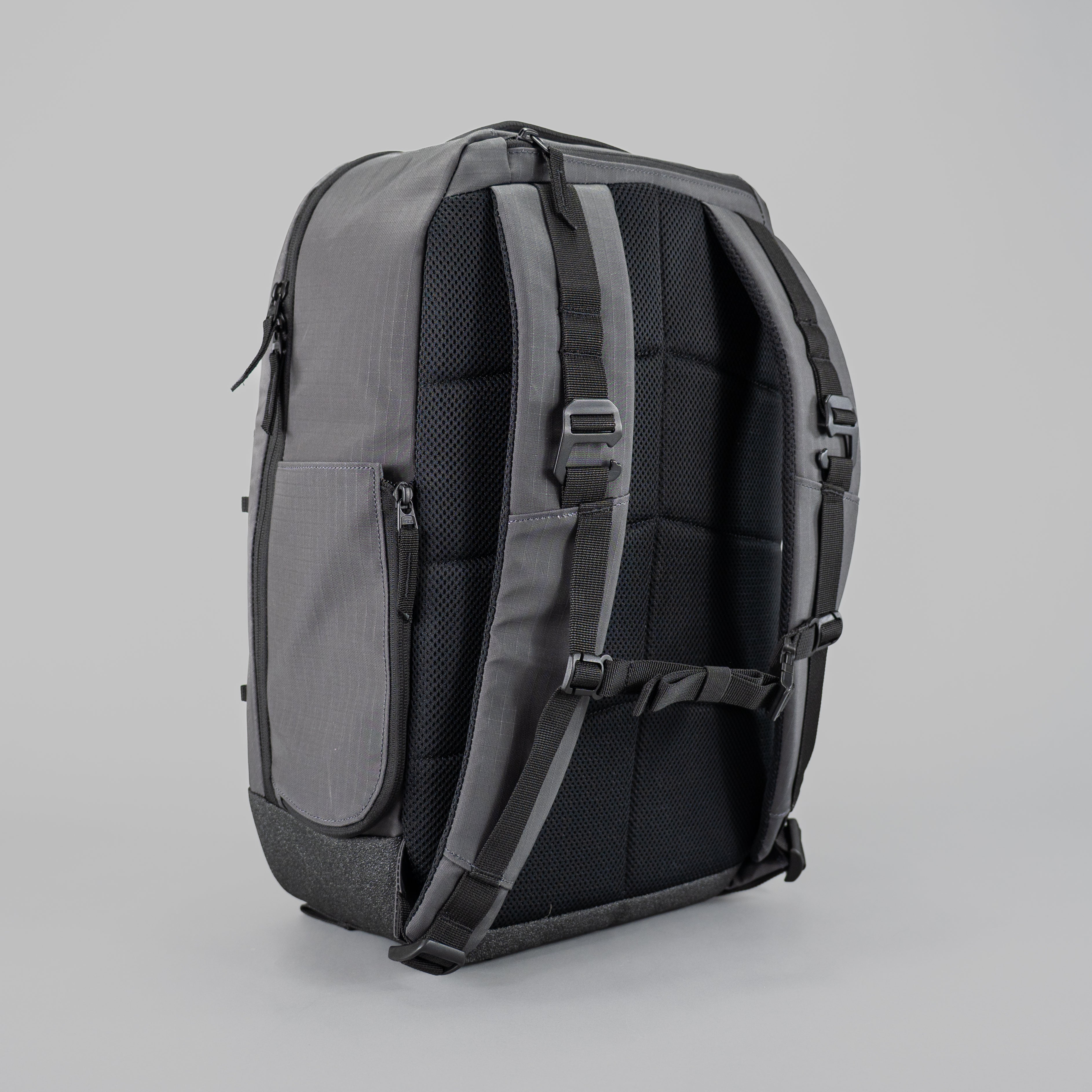 Backpack with multiple compartments and straps on a plain background