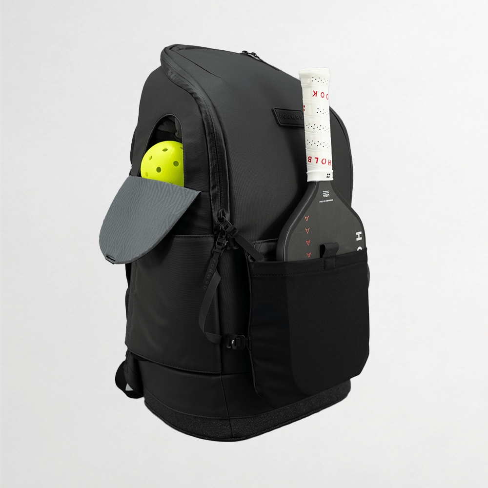 Black backpack with a yellow pickleball ball and paddle on a light gray background