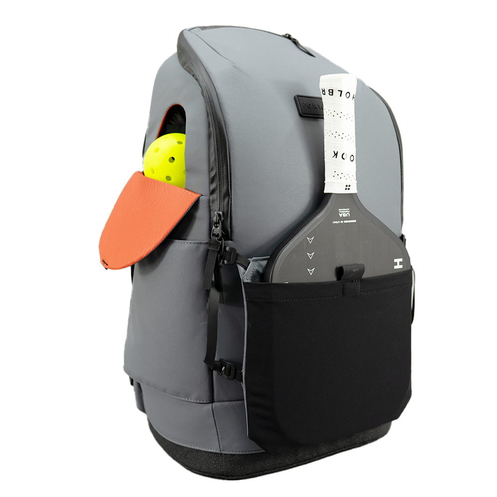 Gray backpack with orange paddle and yellow ball on a white background