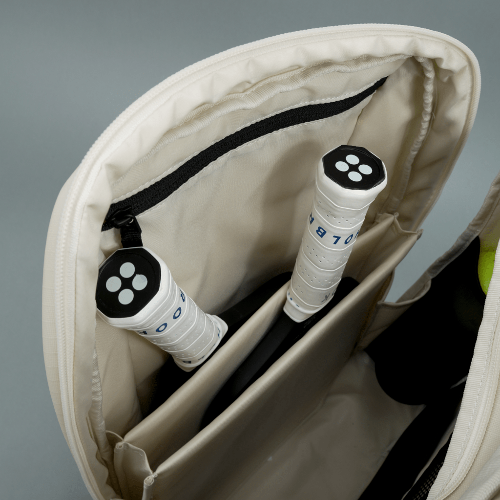 Close-up of a tennis bag with tennis rackets inside on a gray background