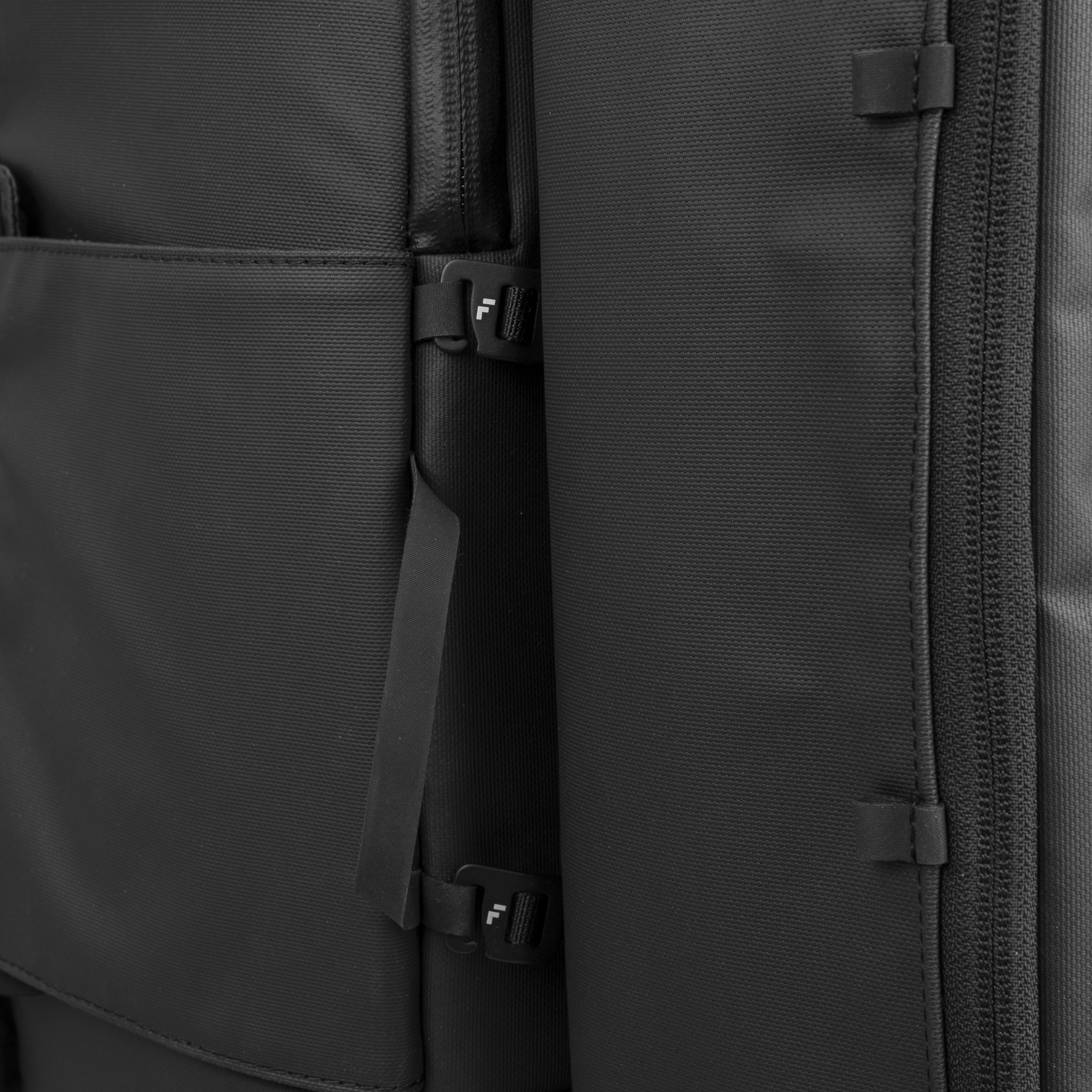 Close-up of a black backpack with zippers and straps.