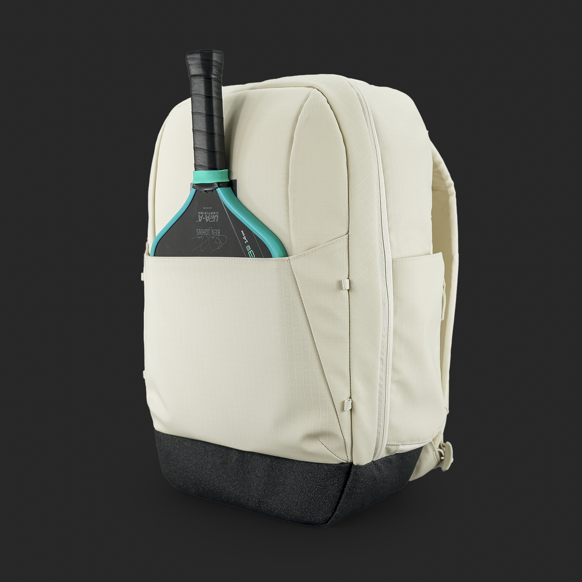 Beige backpack with a pickleball paddle on a black background