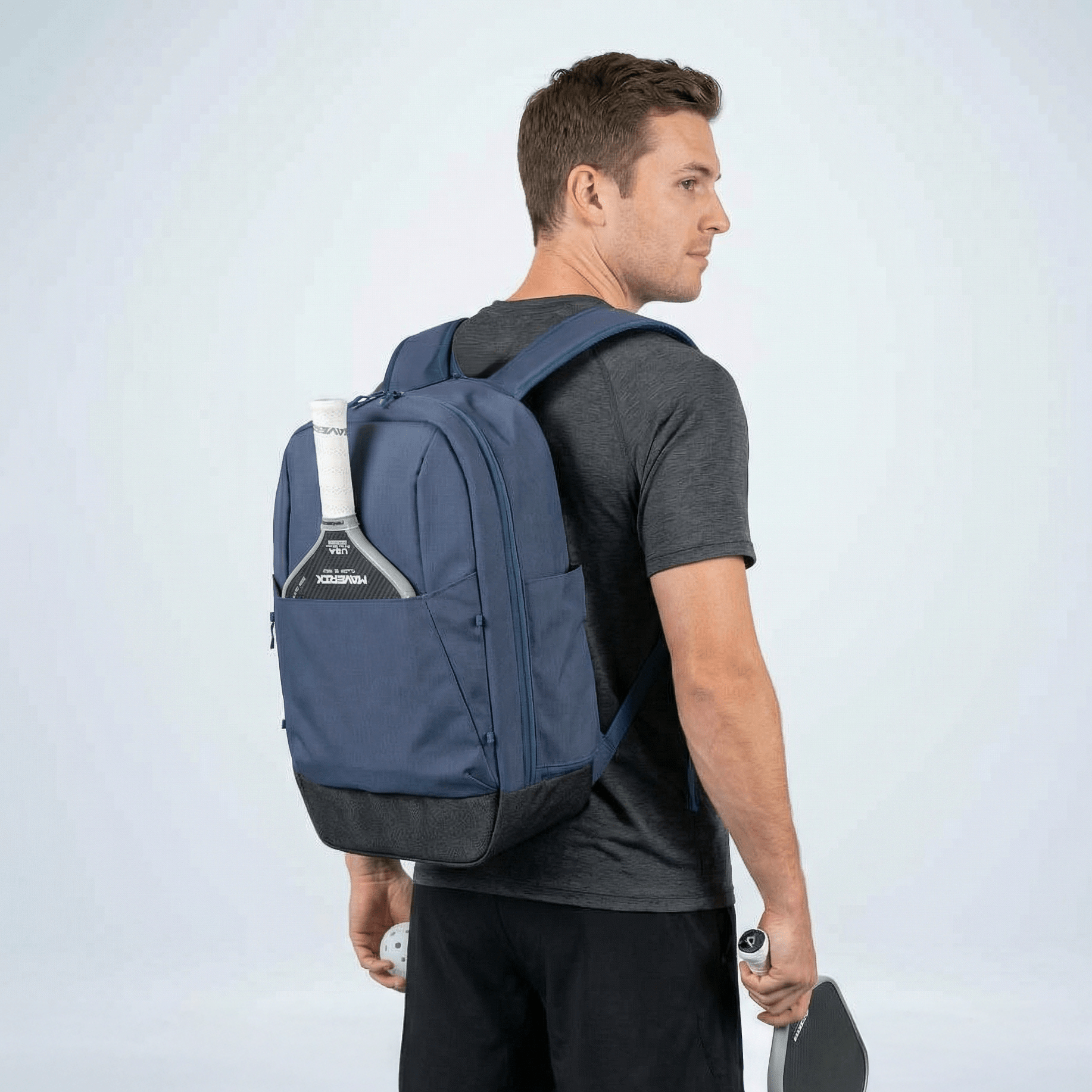 Man wearing a blue backpack on a light gray background