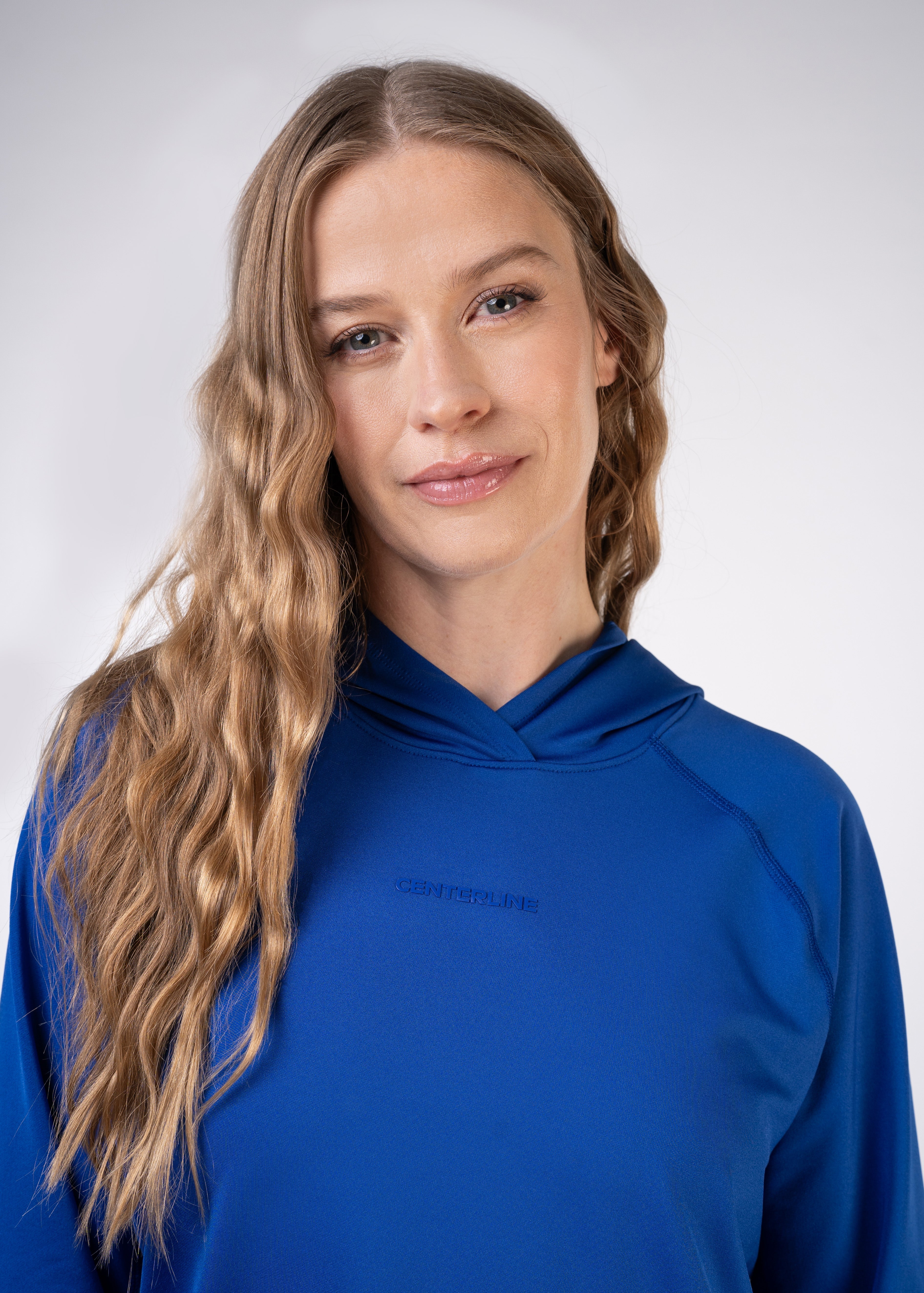 Layering Hoodie Women's - FORWRD - Stay cool and comfortable with our performance-enhanced fabric, designed to regulate your temperature on and off the court. The curved hem allows for freedom of movement, while the extended back hem offers added coverage. Keep your sleeves secure with our discreet thumbholes—perfect for those chilly morning warm-ups or brisk climate play. This top is ideal for layering during warm-ups or tackling cooler conditions in style.