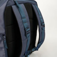 Close-up of a blue backpack with straps on a white background