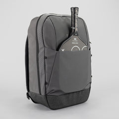 Gray backpack with a paddle in the front pocket on a light gray background