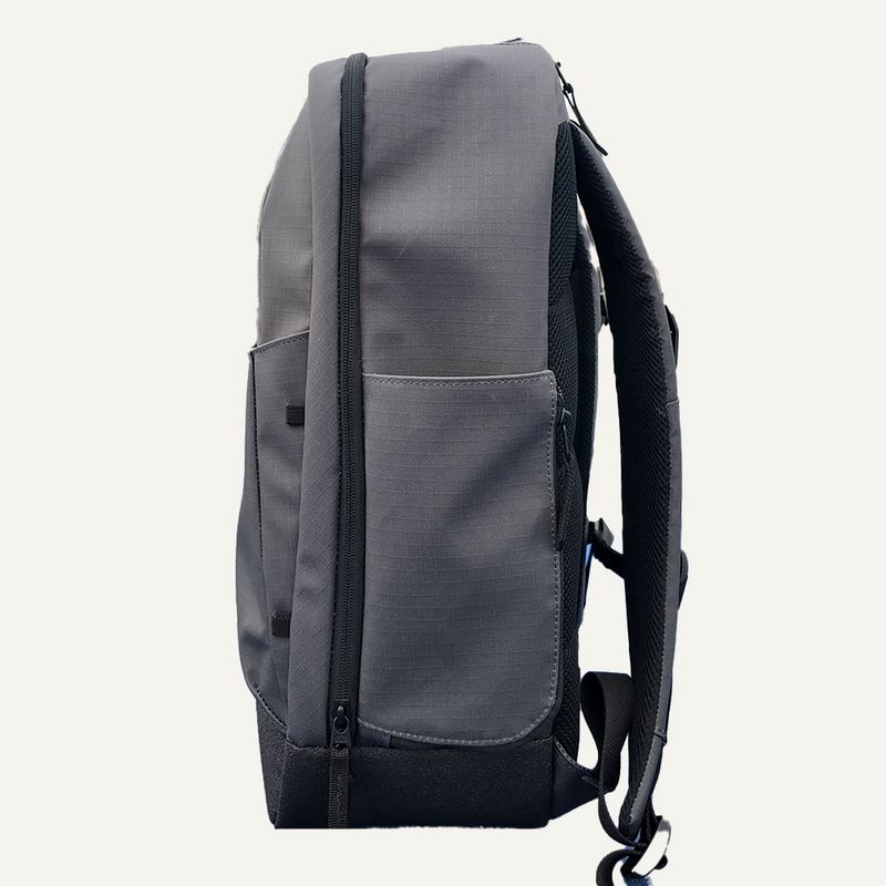 Side view of a gray backpack with a front pocket and straps.