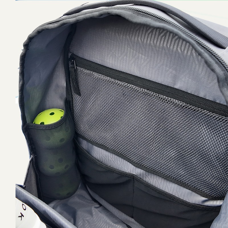 Inside view of a backpack with a yellow ball in a side pocket.