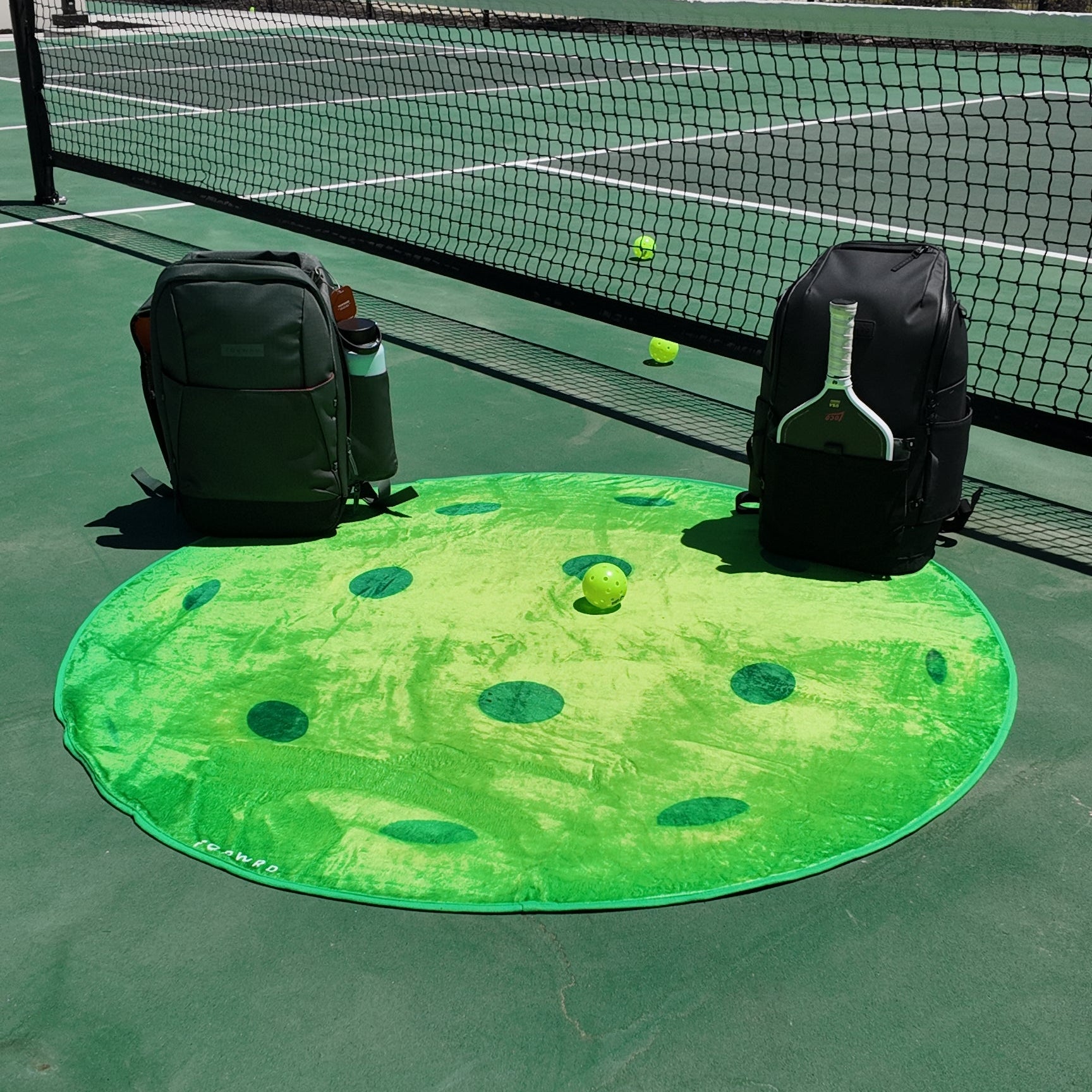Outdoor pickleball blanket laid out on a pickleball court